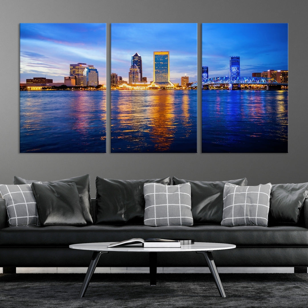 A cozy living room features the Jacksonville Wall Art Canvas Print, a large triptych crafted on museum-quality canvas that beautifully depicts the Jacksonville city skyline at sunset.