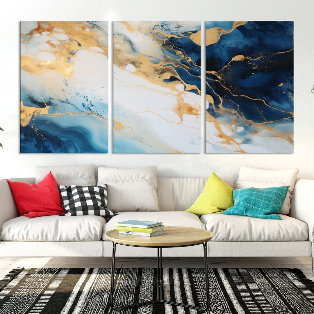 A modern living room featuring museum-quality Blue Gold Abstract Wall Art Print Contemporary art in a triptych arrangement.