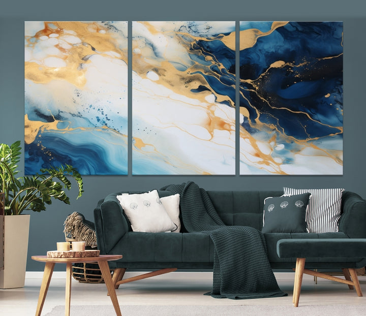 A modern living room featuring museum-quality Blue Gold Abstract Wall Art Print Contemporary art in a triptych arrangement.