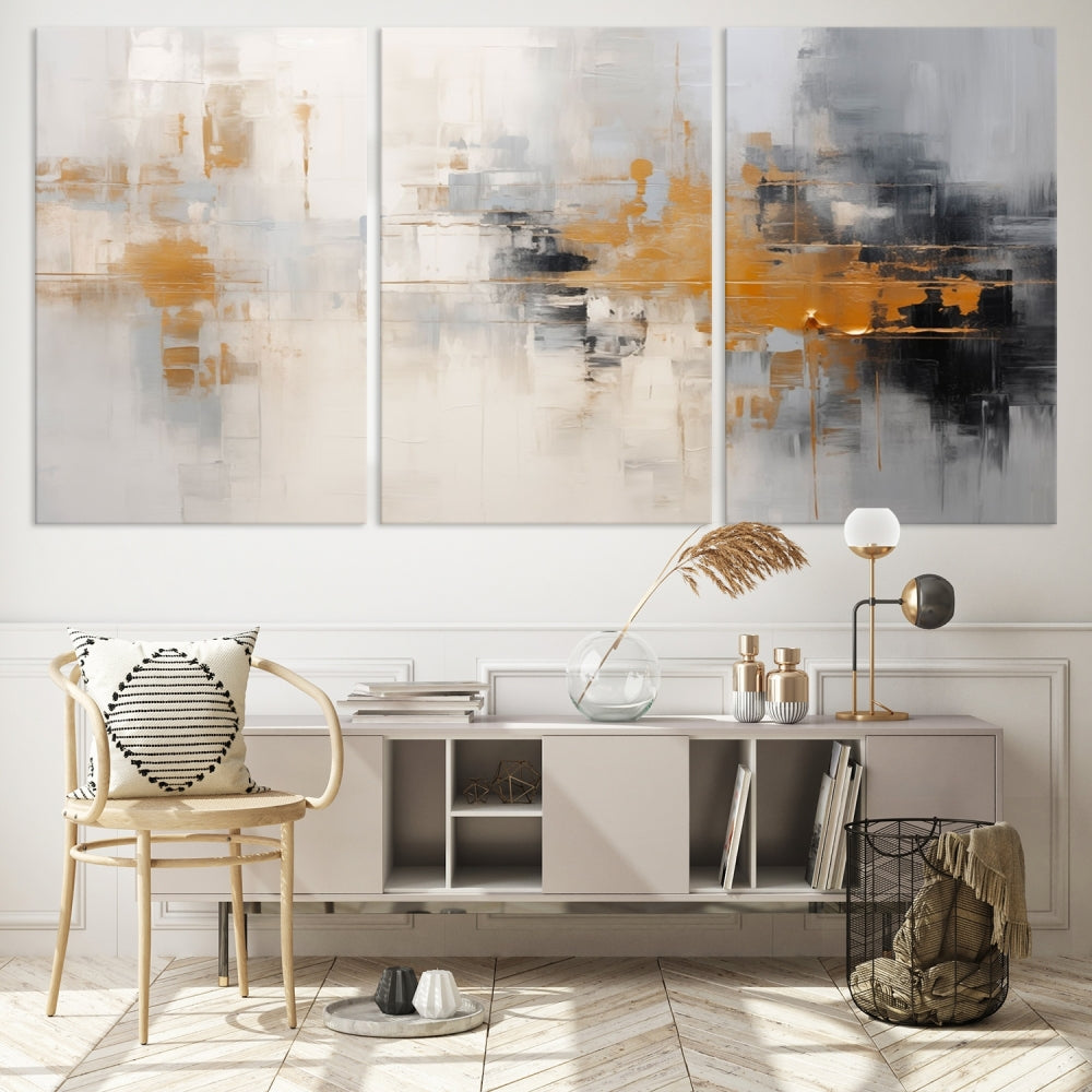 The Orange Pastel Abstract Wall Art Canvas Print, featuring a triptych of orange, white, and black hues, is elegantly displayed on museum-quality canvas.