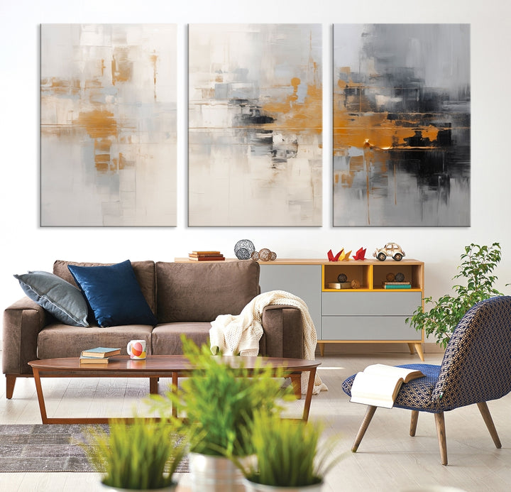 The Orange Pastel Abstract Wall Art Canvas Print, featuring a triptych of orange, white, and black hues, is elegantly displayed on museum-quality canvas.