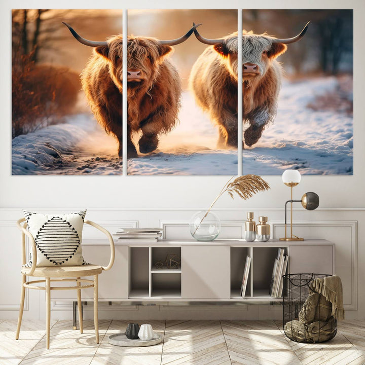 The wall art is a Scottish Highland Cow Horn canvas print featuring cows on a snowy path bathed in warm sunlight, serving as a rustic decor piece.