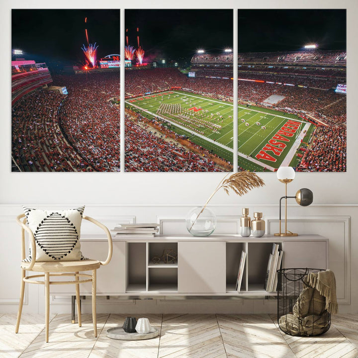 The University of Nebraska Cornhuskers Football Team Print, featuring Lincoln Memorial Stadium in a vibrant triptych canvas with fireworks above and a gallery-quality finish, is elegantly displayed.