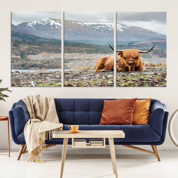 Highland Cow Horn Farm Wall Art Canvas Print is displayed against a wooden wall featuring a mountainous backdrop.