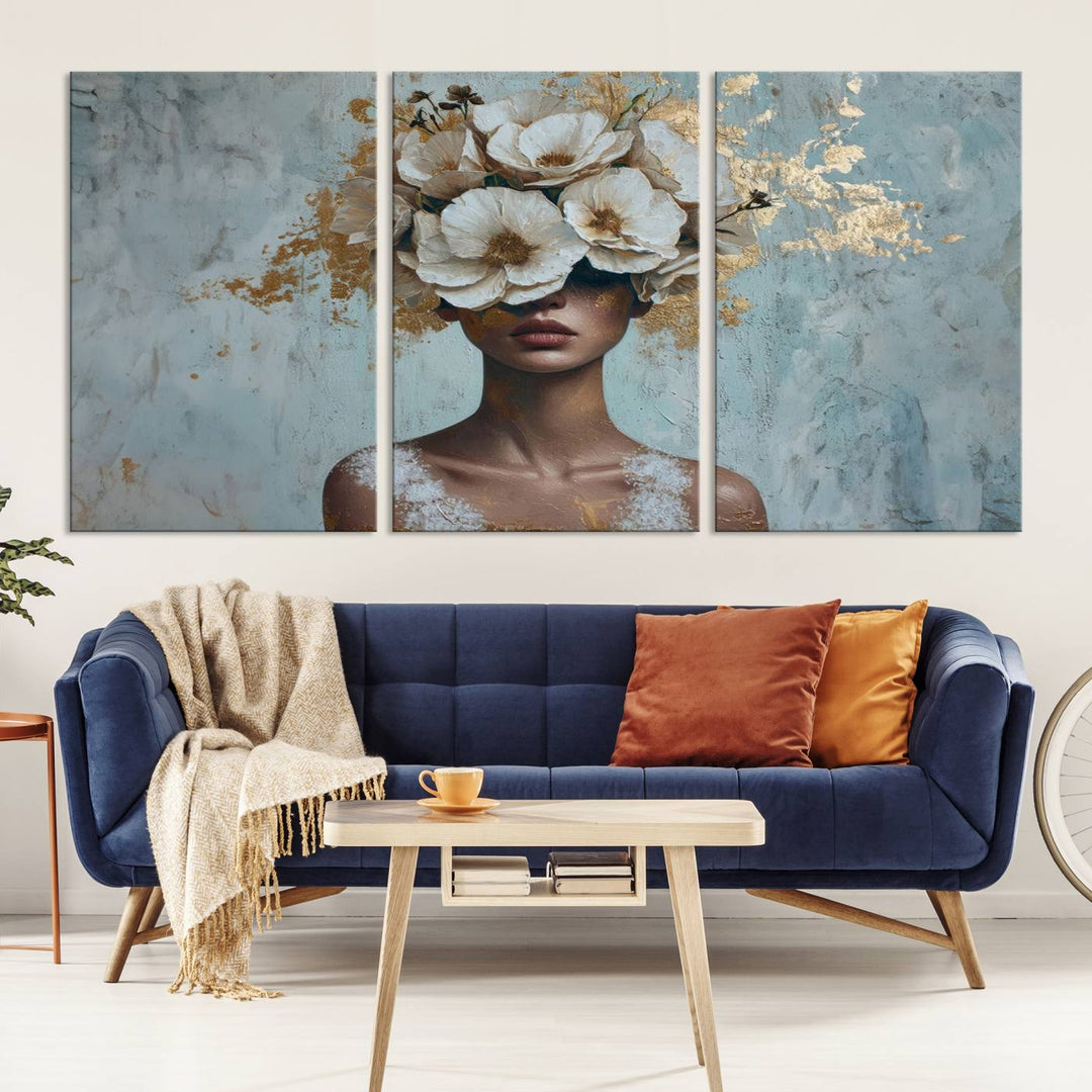 The Golden Petal Silhouette Woman Wall Art Canvas Print, a large 3-panel canvas with a textured gold floral design, serves as a luxurious centerpiece in modern glam settings. The artwork depicts a woman with flowers over her eyes against a textured background and hangs elegantly.