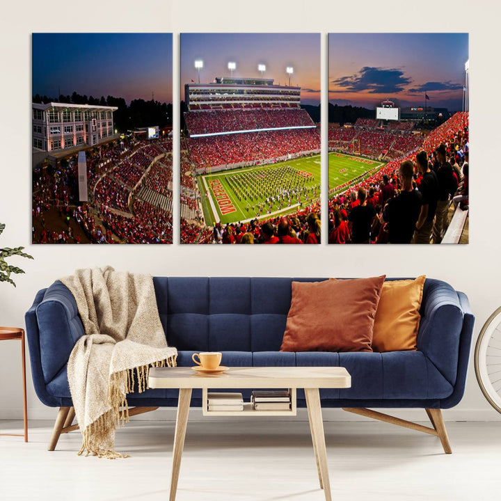 A print of a bustling Carter-Finley Stadium at dusk, featuring fans and a band, captures the essence of NC State Wolfpack football.