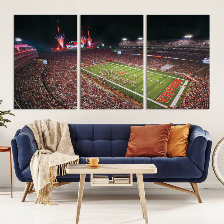 The University of Nebraska Cornhuskers Football Team Print, featuring Lincoln Memorial Stadium in a vibrant triptych canvas with fireworks above and a gallery-quality finish, is elegantly displayed.