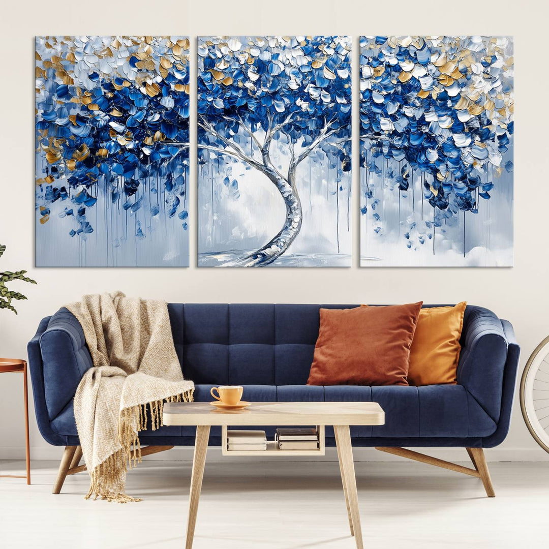 The Blue and Gold Abstract Tree Wall Art showcases a swirl trunk and features blue, silver, and gold leaves on a framed canvas print.