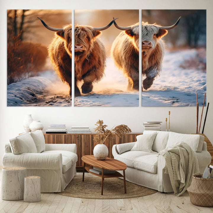 The wall art is a Scottish Highland Cow Horn canvas print featuring cows on a snowy path bathed in warm sunlight, serving as a rustic decor piece.