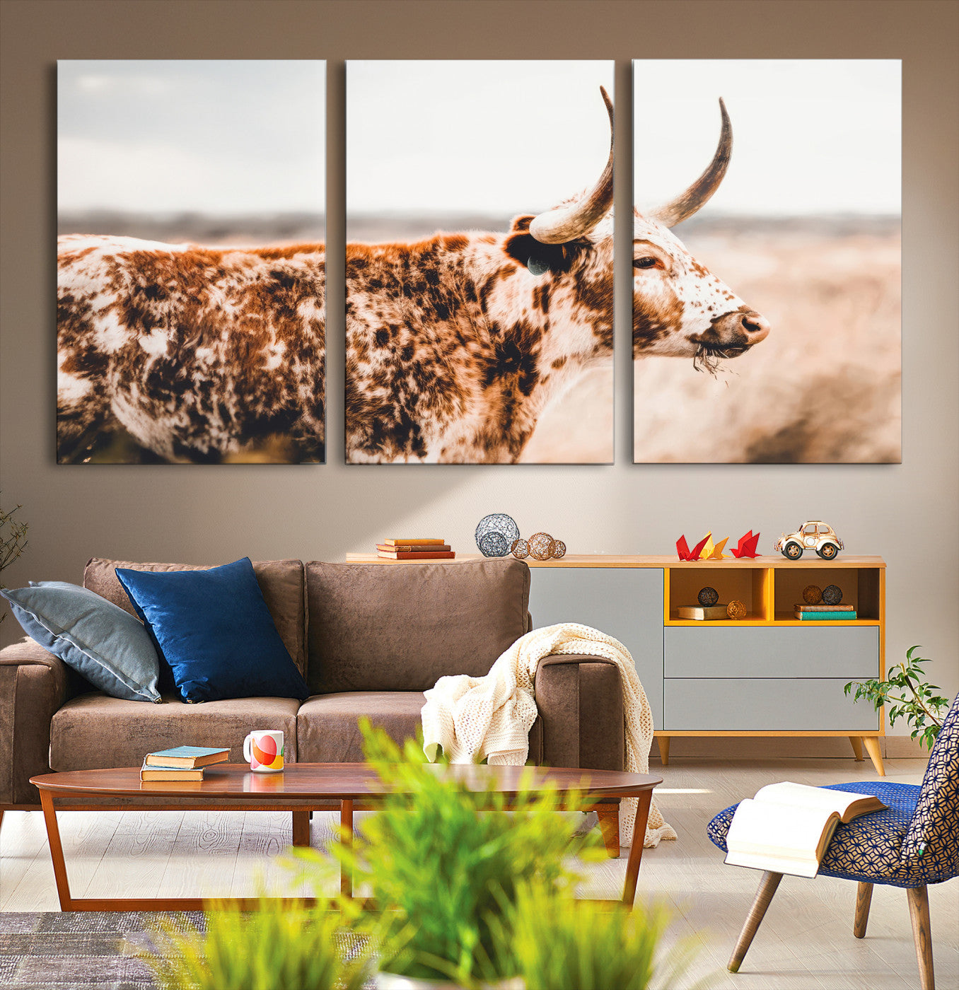 Speckled Texas longhorn with curved horns standing in a warm-toned prairie, perfect for rustic or country-style home decor.