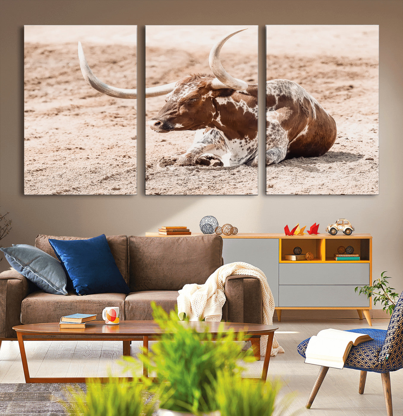 Texas Longhorn bull resting on dusty ground with warm tones, ideal for rustic western or farmhouse-themed wall decor.