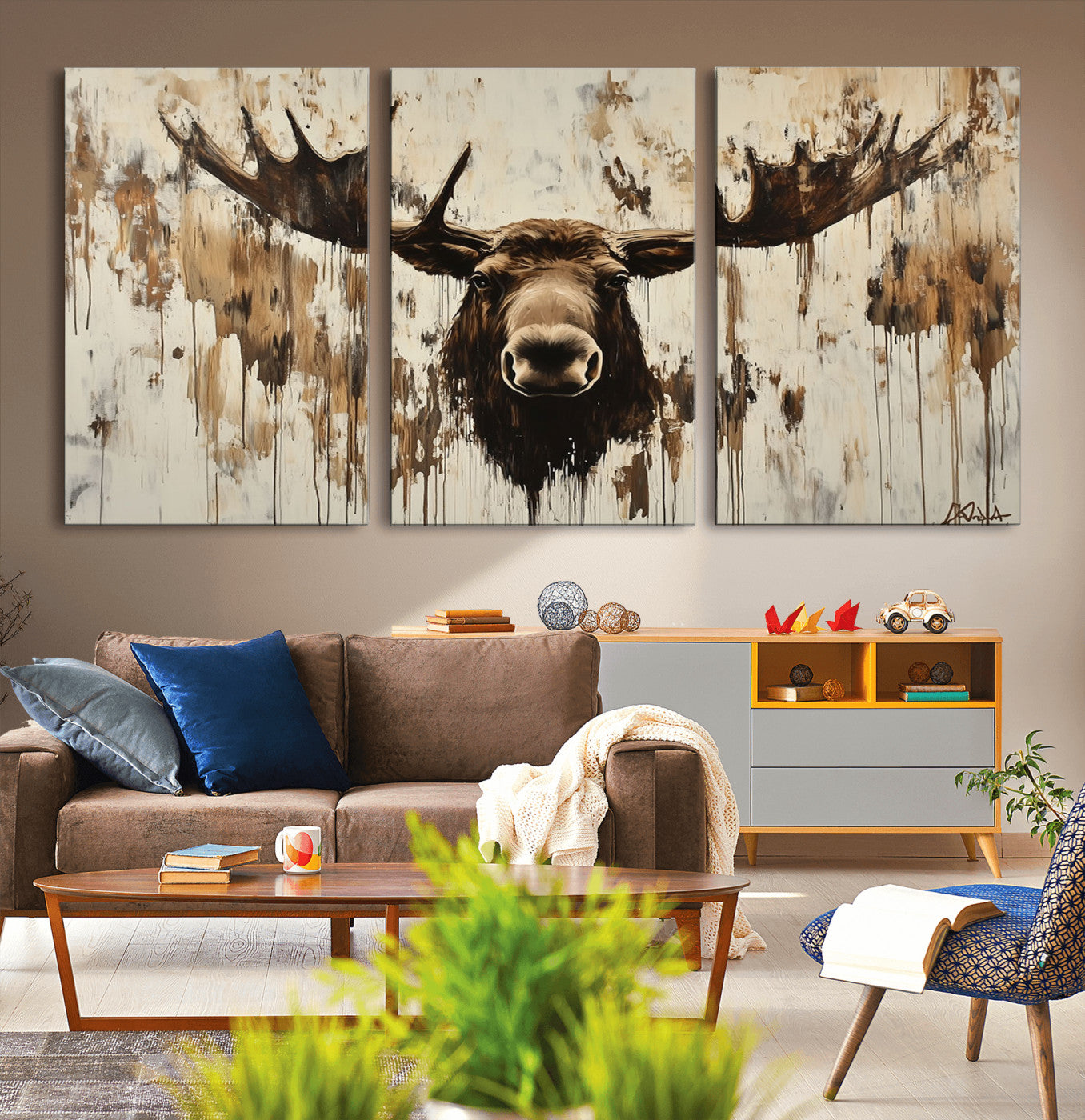 Expressive painting of a moose head with wide antlers in dark brown and beige tones, featuring paint drips and splatters on a light textured background, creating a striking rustic wall art canvas.