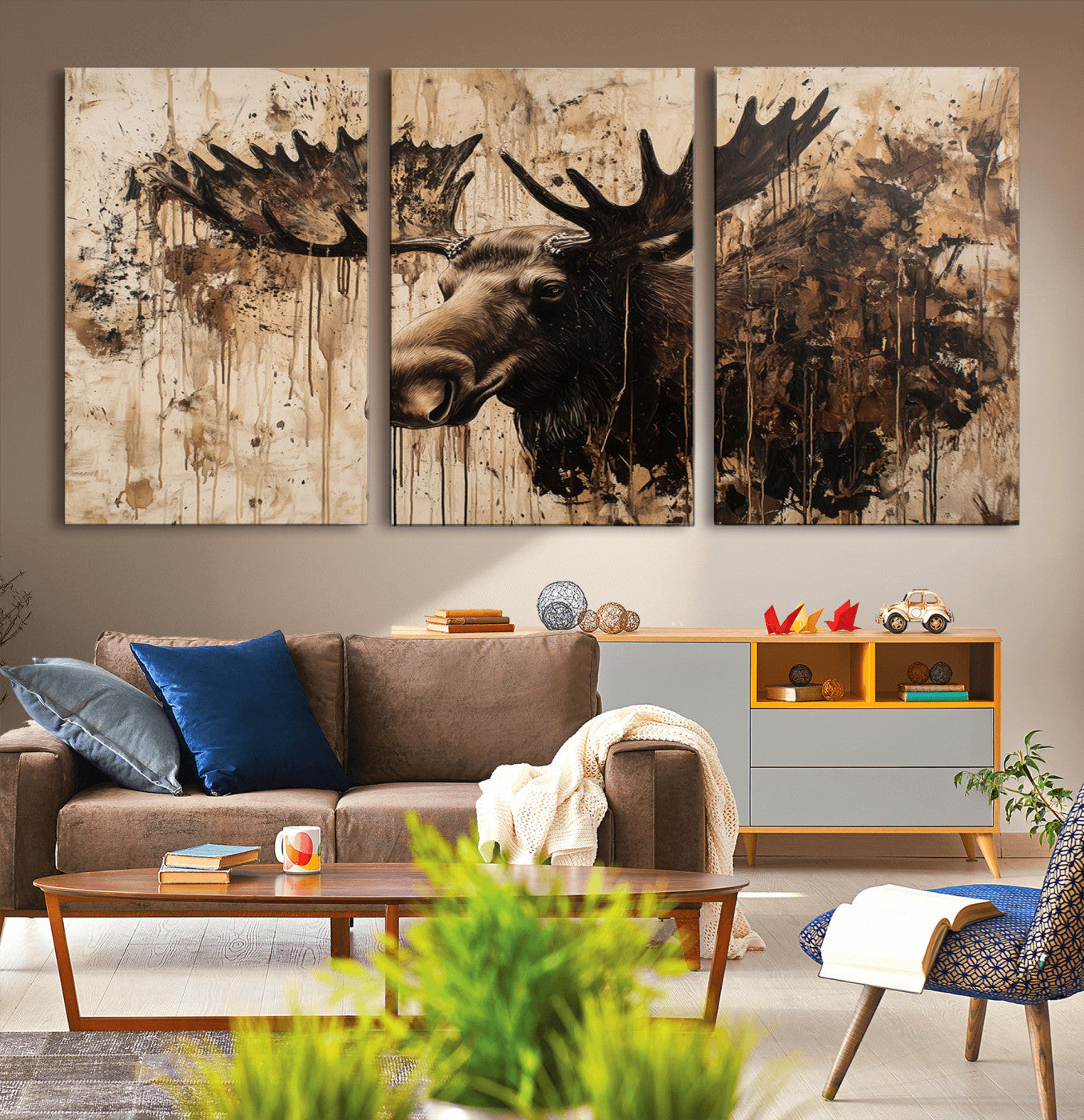 Artistic painting of a moose head with large antlers in shades of brown and black, with paint splatters and drips on a beige textured background, creating a rustic and expressive wall art canvas.