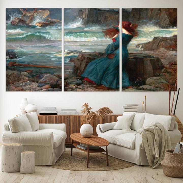 The Miranda by the Shore Wall Art Canvas Print depicts a woman in a blue dress standing by the sea, watching a shipwreck.