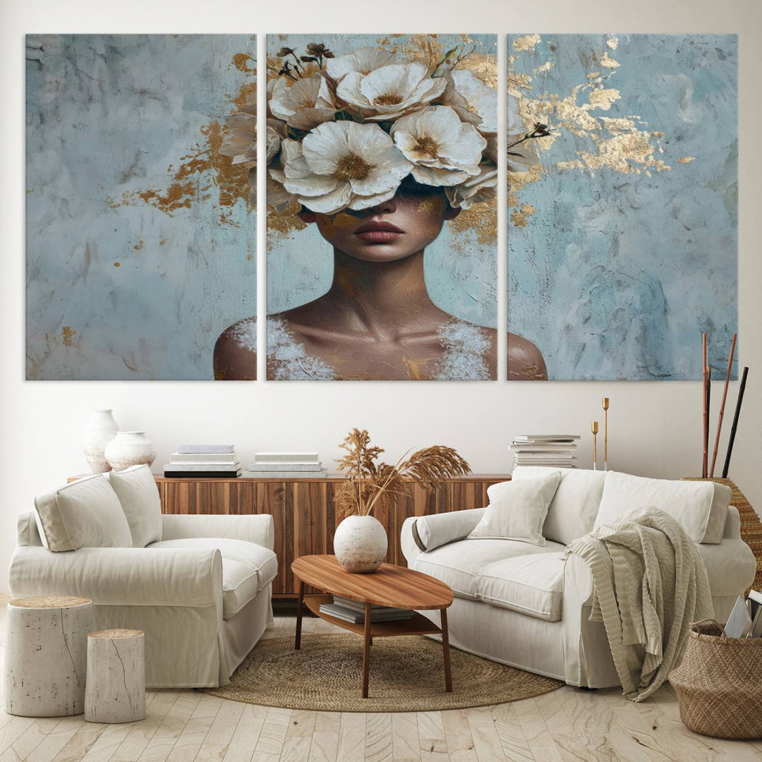 The Golden Petal Silhouette Woman Wall Art Canvas Print, a large 3-panel canvas with a textured gold floral design, serves as a luxurious centerpiece in modern glam settings. The artwork depicts a woman with flowers over her eyes against a textured background and hangs elegantly.