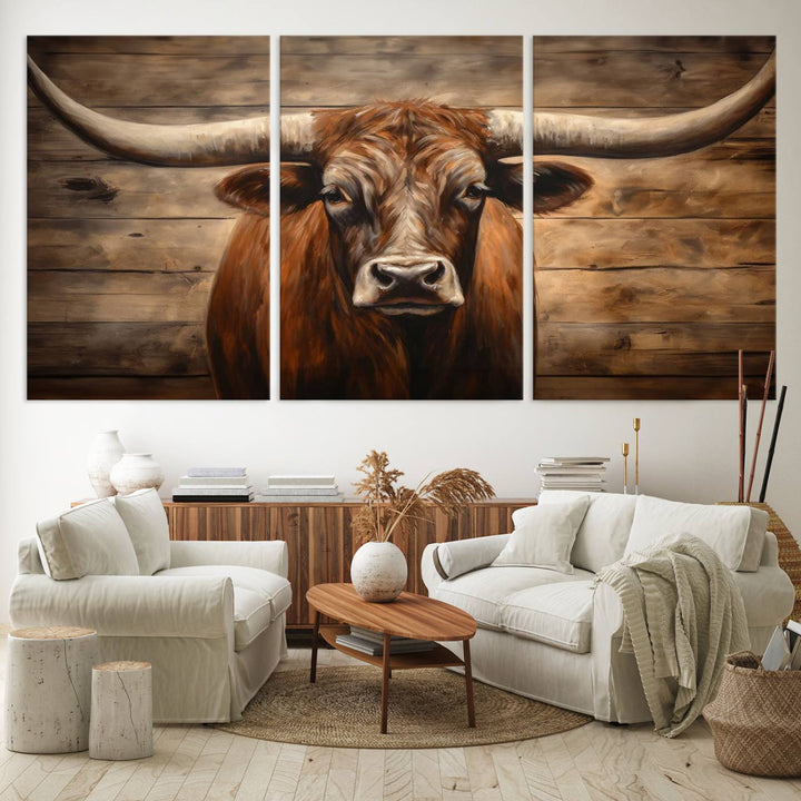 The Longhorn Bull Wall Art, a ready-to-hang canvas print, showcases an image of a brown longhorn cow set against a wooden background, perfect for those looking to enhance their space with rustic farmhouse and western barn decor.