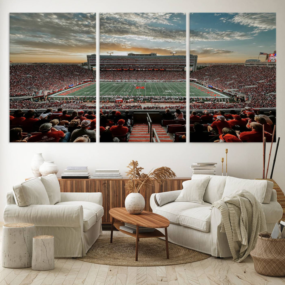 The living room features a stunning triptych of Lincoln Memorial Stadium wall art canvas print, celebrating the University of Nebraska Cornhuskers football team. This piece serves as captivating wall art, showcasing a gallery-quality finish.