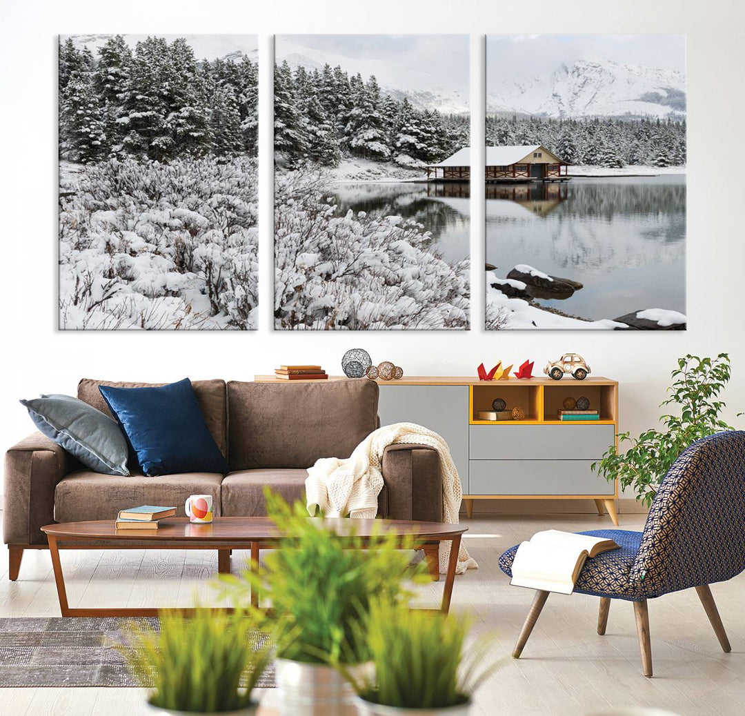 Experience the beauty of winter with the "Cabin by the Lake Canvas Wall Art," showcasing a serene snowy landscape. This rustic nature decor features a cozy cabin nestled amid snow-laden trees, set against a breathtaking mountain view, perfect for enhancing your living room.