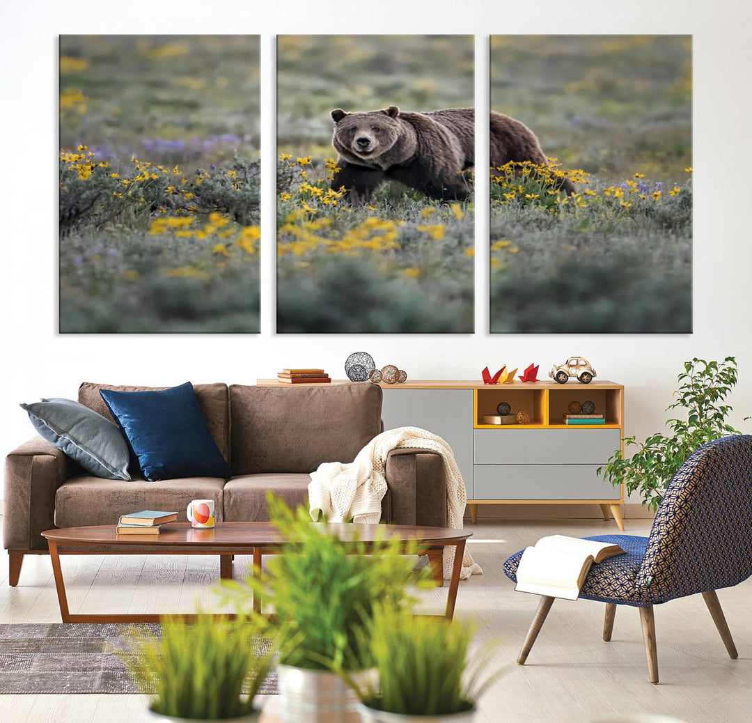 The "Grizzly 399 in Wild Flowers Wall Art Canvas Print" features a grizzly bear strolling through a field of yellow and purple flowers, beautifully showcased as a triptych. This handcrafted piece, proudly made in the USA, adds charm and sophistication to your space.