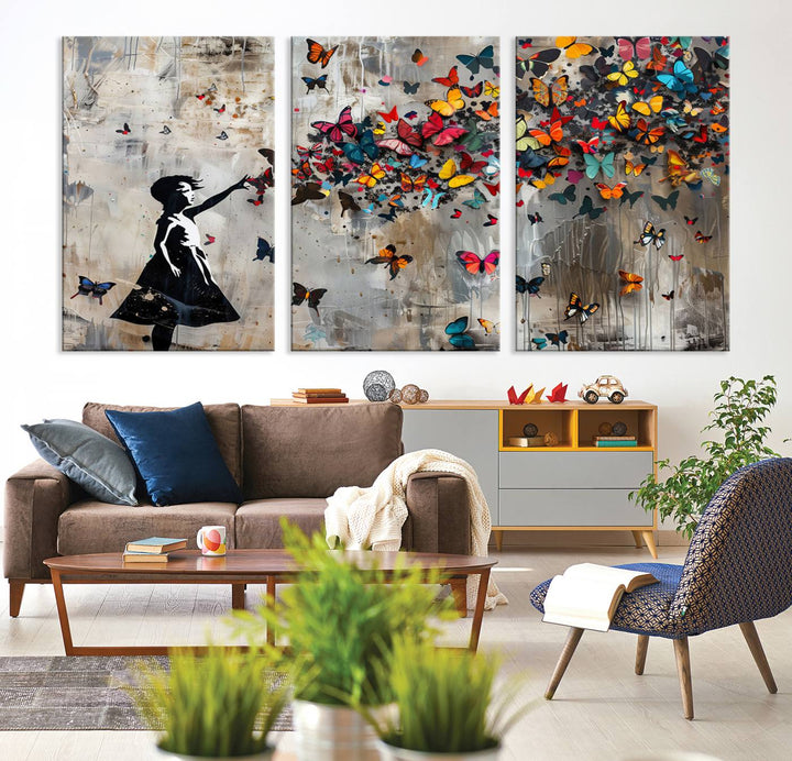 The Banksy Butterfly Girl 3-Piece Modern Graffiti Canvas Wall Art features a silhouette of a girl reaching for butterflies.