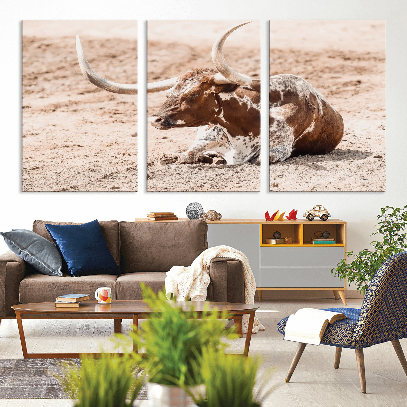 Texas Longhorn bull resting on dusty ground with warm tones, ideal for rustic western or farmhouse-themed wall decor.