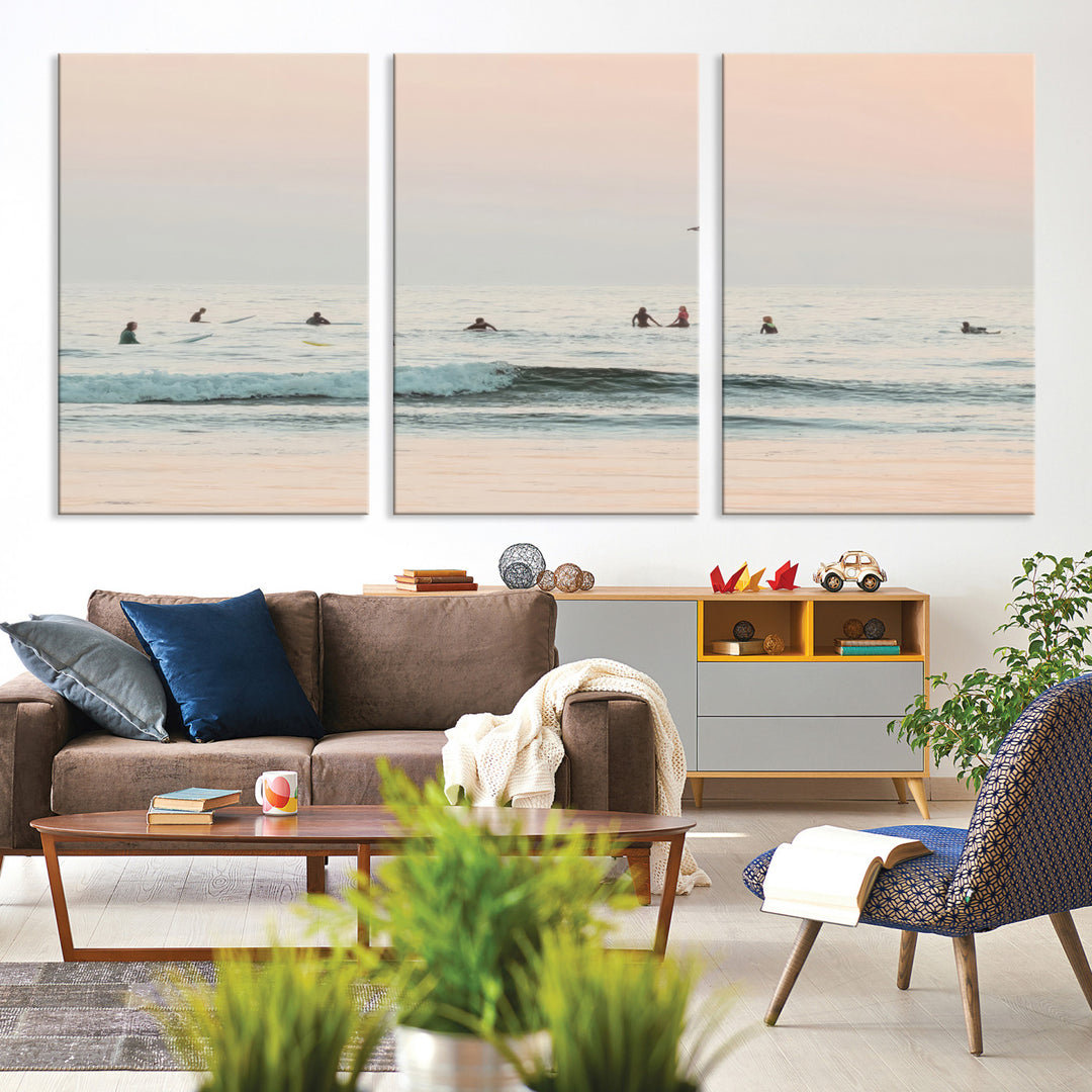 Dreamy photo of surfers waiting on soft pastel waves under a pink sunset sky, ideal for soft coastal minimalist or serene ocean-themed home decor.