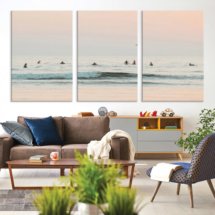 Dreamy photo of surfers waiting on soft pastel waves under a pink sunset sky, ideal for soft coastal minimalist or serene ocean-themed home decor.