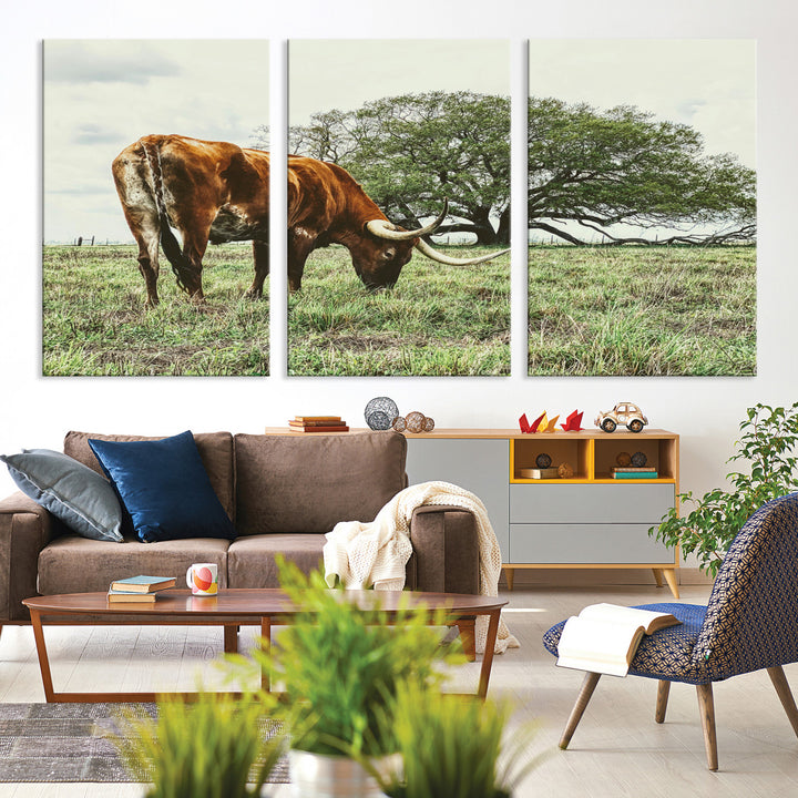 A Texas Longhorn grazing in a green pasture with a large tree in the background, evoking a rustic Western and farmhouse aesthetic.