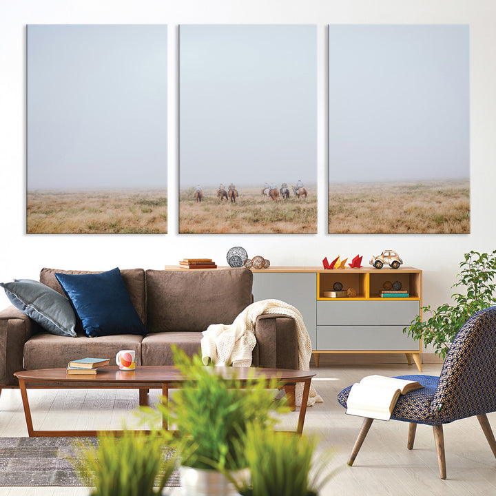 A group of horseback riders moving through a fog-shrouded field, evoking a calm Western scene with golden grasses and soft horizons.