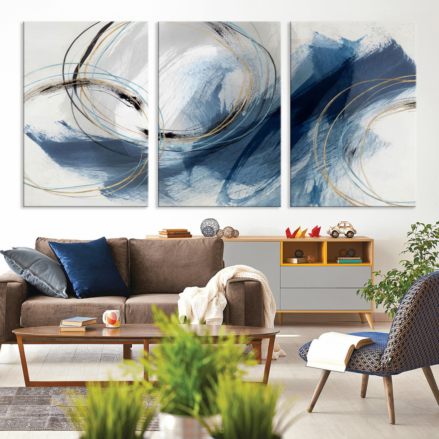 Abstract wall art featuring dynamic brush strokes in shades of blue and gray, overlaid with delicate circular line patterns in gold, black, and light blue on a white background.