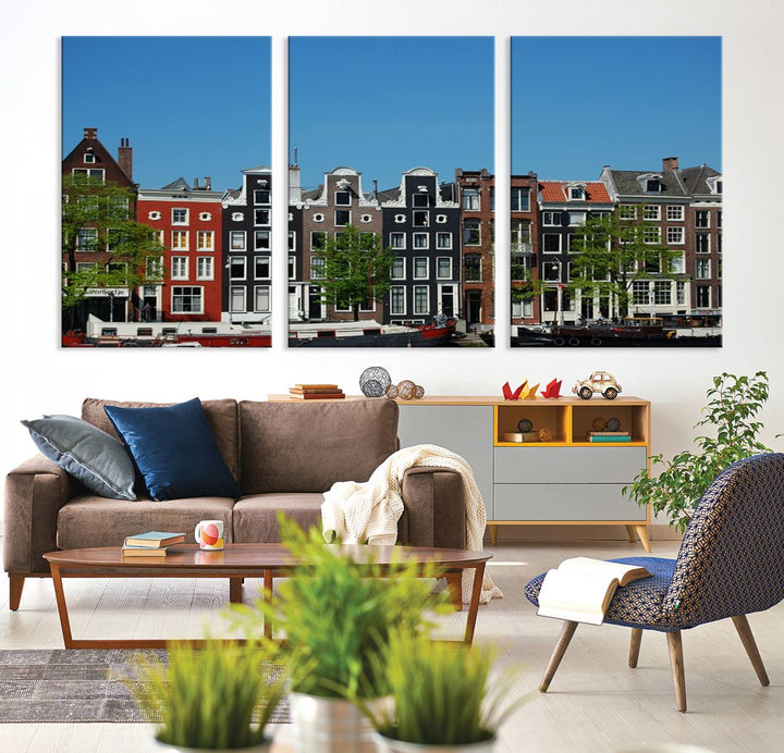 The Amsterdam City Wall Art Canvas Print showcases colorful traditional canal houses and boats set against a clear blue sky.