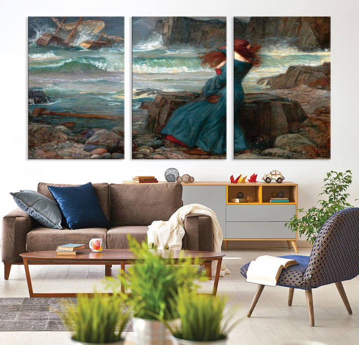 The Miranda by the Shore Wall Art Canvas Print depicts a woman in a blue dress standing by the sea, watching a shipwreck.