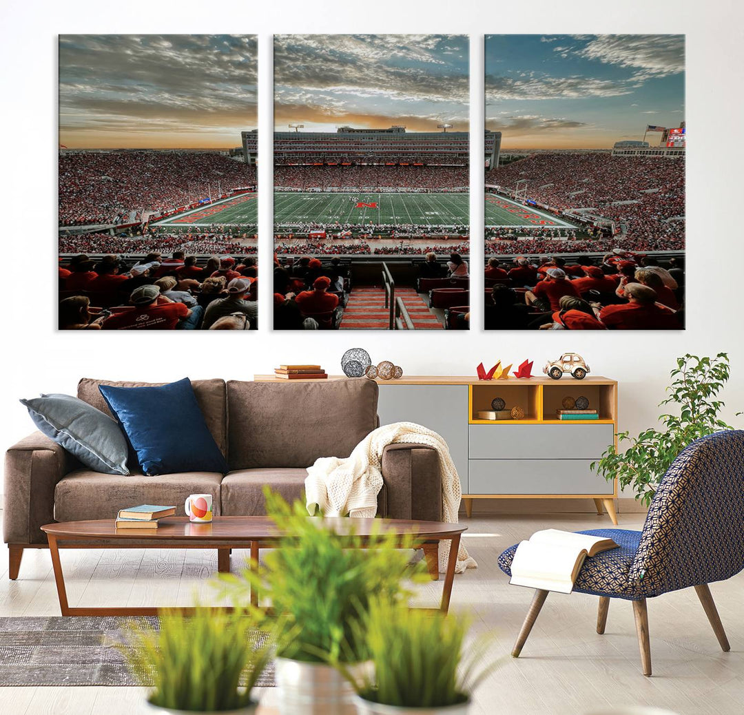 The living room features a stunning triptych of Lincoln Memorial Stadium wall art canvas print, celebrating the University of Nebraska Cornhuskers football team. This piece serves as captivating wall art, showcasing a gallery-quality finish.