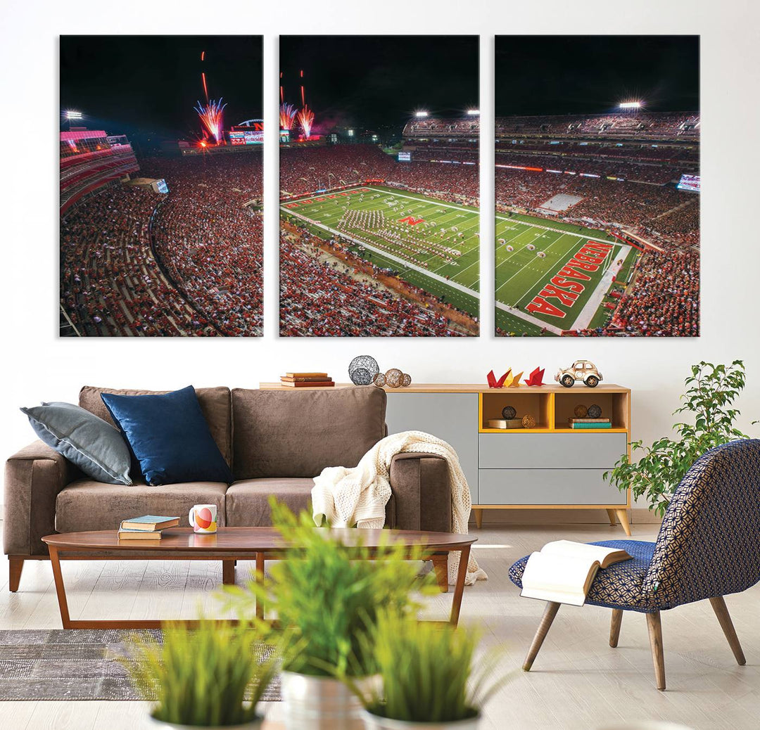 The University of Nebraska Cornhuskers Football Team Print, featuring Lincoln Memorial Stadium in a vibrant triptych canvas with fireworks above and a gallery-quality finish, is elegantly displayed.