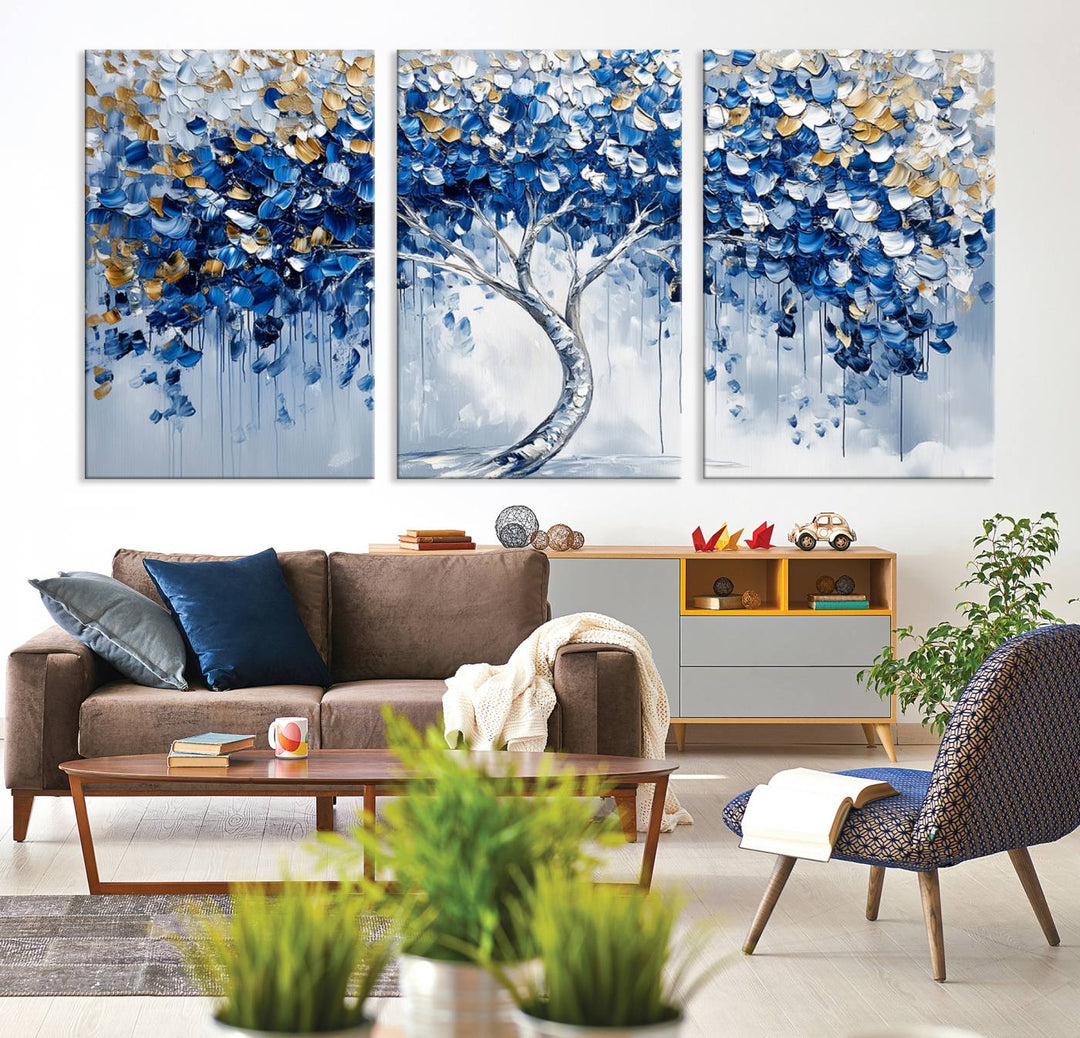 The Blue and Gold Abstract Tree Wall Art showcases a swirl trunk and features blue, silver, and gold leaves on a framed canvas print.