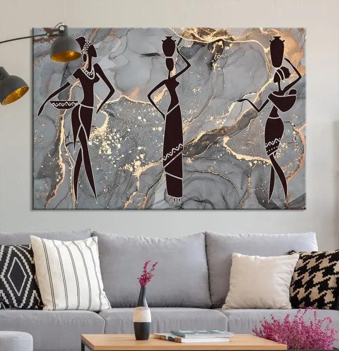 The Abstract African Women Silhouette Canvas Print is a 3-panel wall art with a gray marble texture and gold accents, enhancing the modern aesthetic of the room.