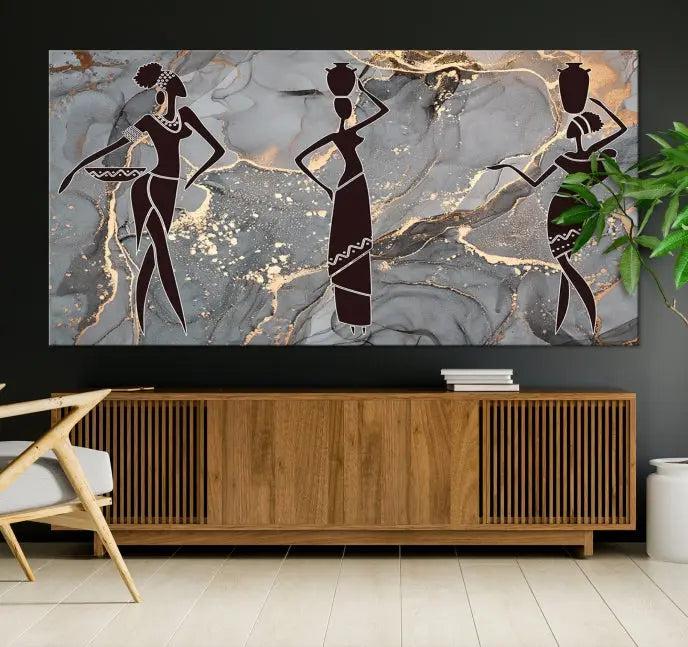 The Abstract African Women Silhouette Canvas Print is a 3-panel wall art with a gray marble texture and gold accents, enhancing the modern aesthetic of the room.