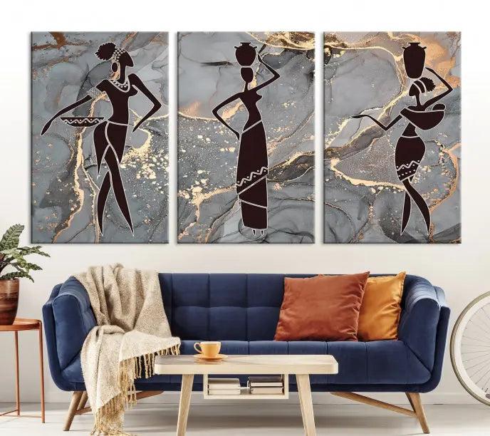 The Abstract African Women Silhouette Canvas Print is a 3-panel wall art with a gray marble texture and gold accents, enhancing the modern aesthetic of the room.