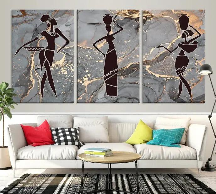 The Abstract African Women Silhouette Canvas Print is a 3-panel wall art with a gray marble texture and gold accents, enhancing the modern aesthetic of the room.