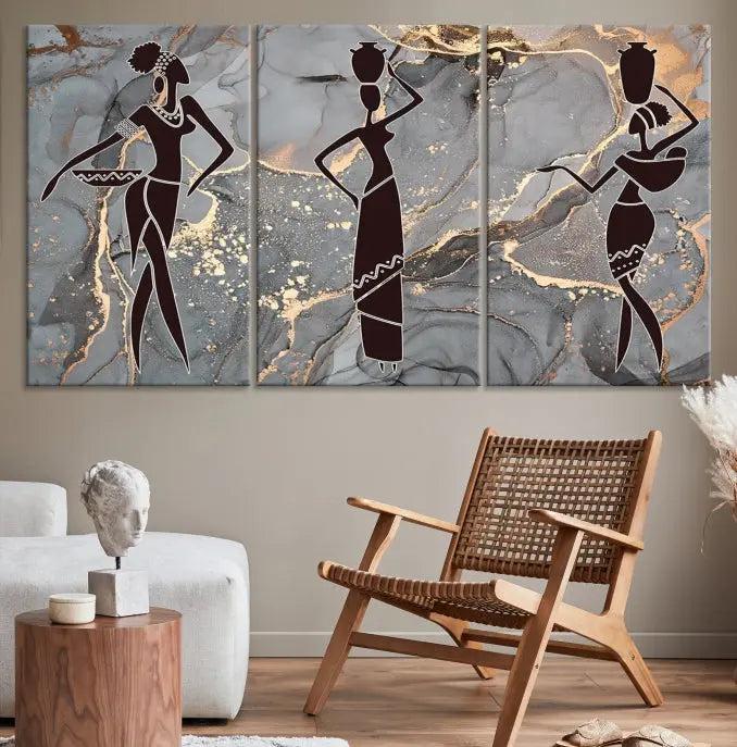 The Abstract African Women Silhouette Canvas Print is a 3-panel wall art with a gray marble texture and gold accents, enhancing the modern aesthetic of the room.