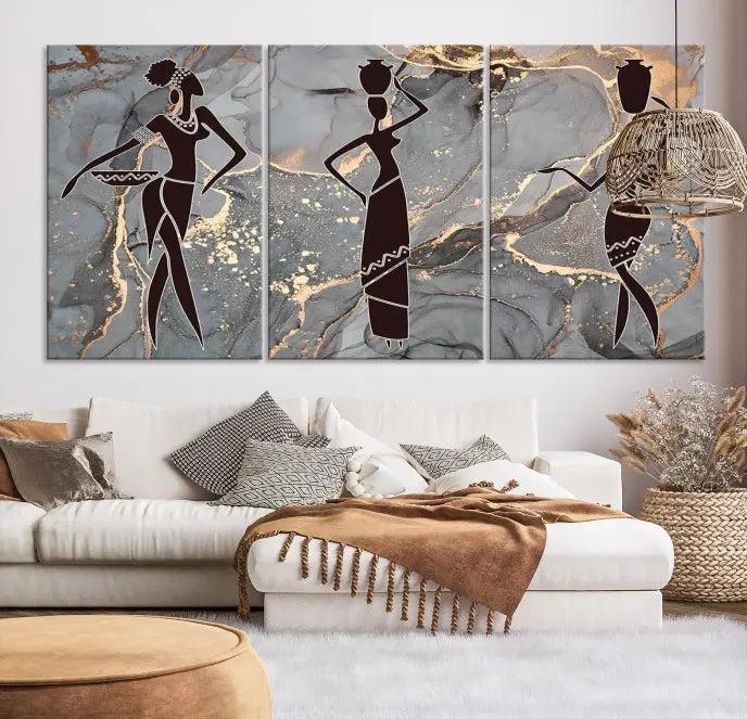 The Abstract African Women Silhouette Canvas Print is a 3-panel wall art with a gray marble texture and gold accents, enhancing the modern aesthetic of the room.