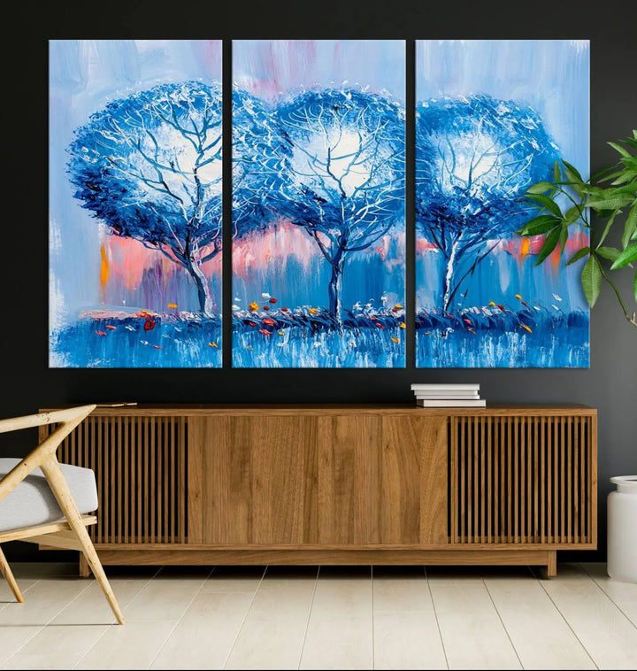 The living room showcases the Abstract Blue Trees Trendy Wall Art Canvas Print, elegantly featuring a triptych of blue trees against a pink background.