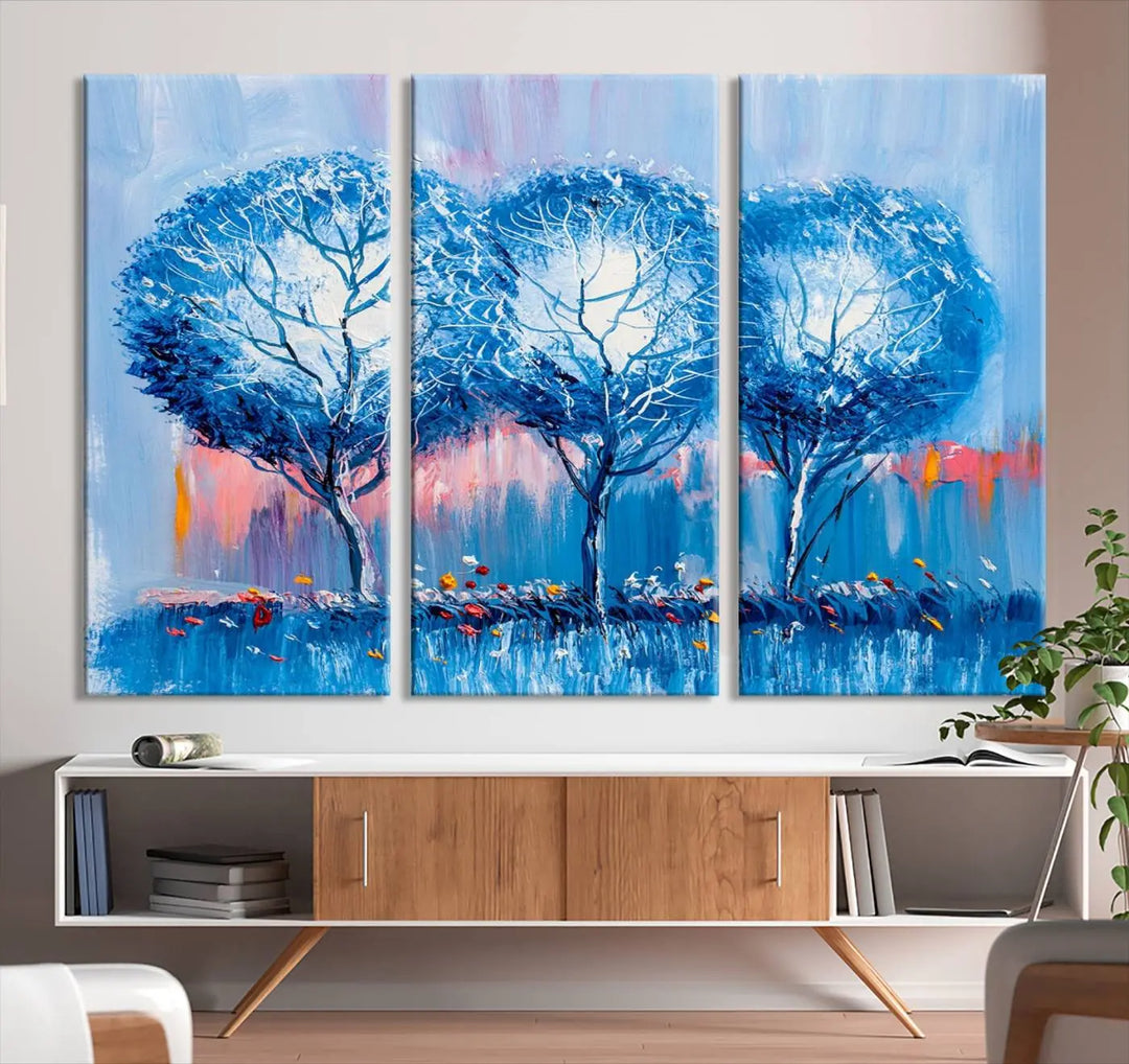 The living room showcases the Abstract Blue Trees Trendy Wall Art Canvas Print, elegantly featuring a triptych of blue trees against a pink background.