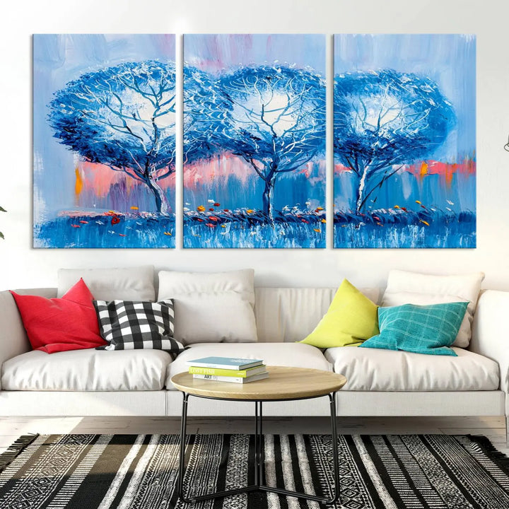 The living room showcases the Abstract Blue Trees Trendy Wall Art Canvas Print, elegantly featuring a triptych of blue trees against a pink background.