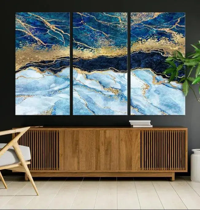 The room features a captivating Abstract Blue and Gold Marble Canvas Print displayed as a large 3-panel wall decor, infusing the space with modern elegance.