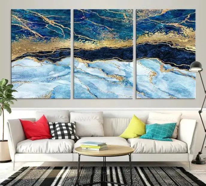 The room features a captivating Abstract Blue and Gold Marble Canvas Print displayed as a large 3-panel wall decor, infusing the space with modern elegance.