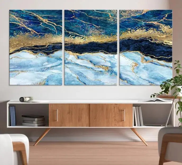 The room features a captivating Abstract Blue and Gold Marble Canvas Print displayed as a large 3-panel wall decor, infusing the space with modern elegance.