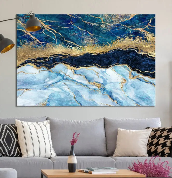 The room features a captivating Abstract Blue and Gold Marble Canvas Print displayed as a large 3-panel wall decor, infusing the space with modern elegance.