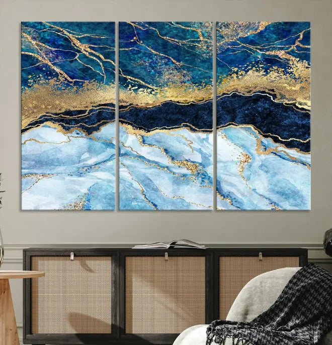 The room features a captivating Abstract Blue and Gold Marble Canvas Print displayed as a large 3-panel wall decor, infusing the space with modern elegance.