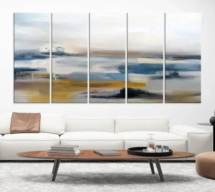 A captivating 3-panel abstract landscape wall art in modern blue, gold, and white hues graces the dark wall, enhancing the space with a touch of contemporary decor.